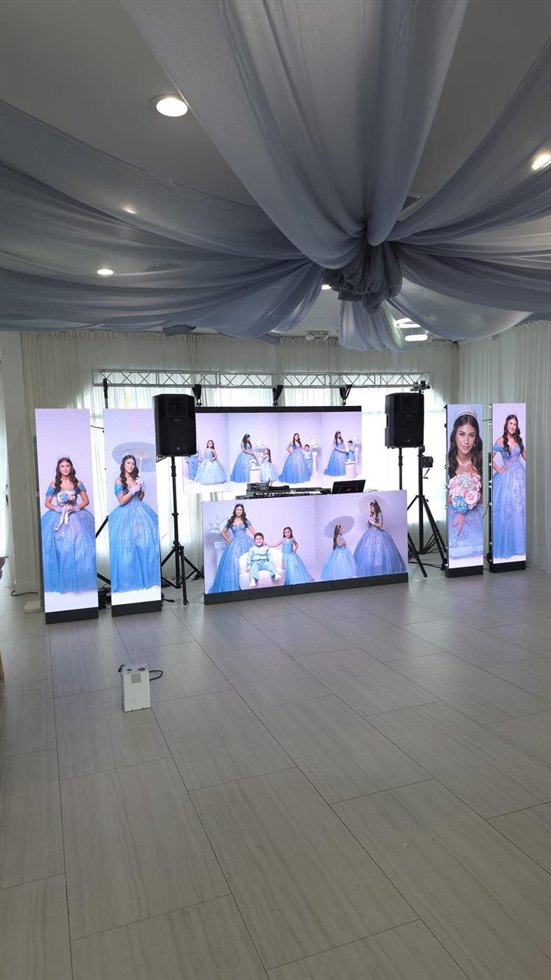 LED video walls and speakers set up under white ceiling drape